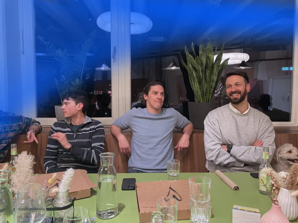 dnl team members talking and laughing around a table in the Berlin office